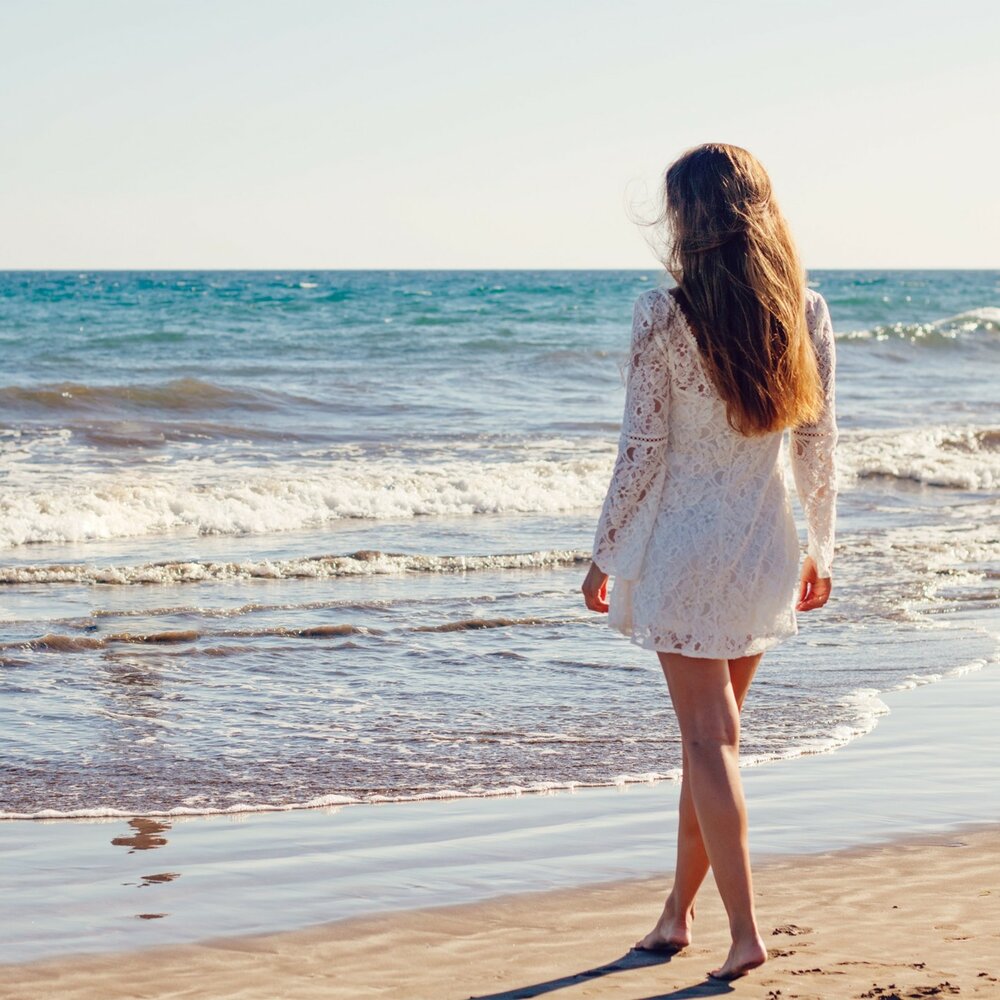 Девушка смотрит на море со спины фото
