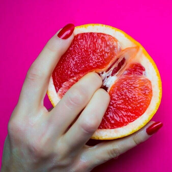 Женский половой персик. Пальцы в грейпфруте. Грейпфрут. Грейпфрут в руке. Грейпфрут в разрезе.